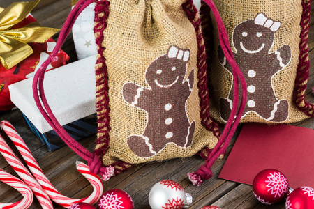 Close up of  two burlap Christmas bags with glass jar of jam inside bags.の写真素材