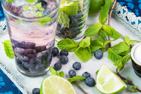 Close up of glass with blueberry mojito cocktail on a metal tray.の写真素材