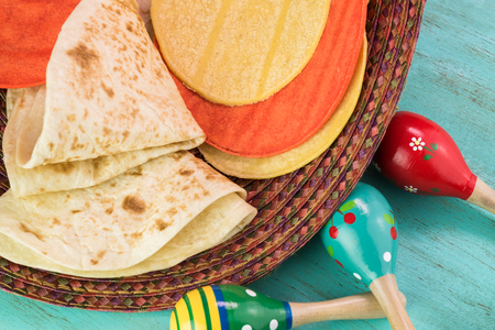 Close up of flour and corn tortillas on a blue wooden background.