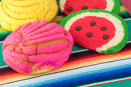 Close up of mexican butter cookies and colorful powdered sugar bread on tradition mexican table runner.の写真素材