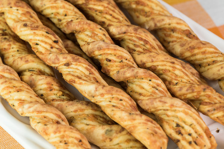 Close up of garlic cheese breadsticks on a white tray.
