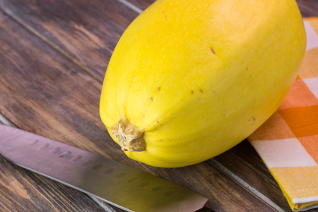 Close up of whole spaghetti squash on a wooden background.の写真素材