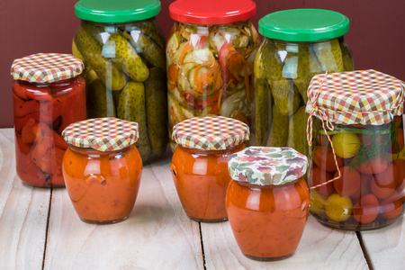 Close up of  pickled vegetables in glass jars and roasted red pepper spread.の写真素材