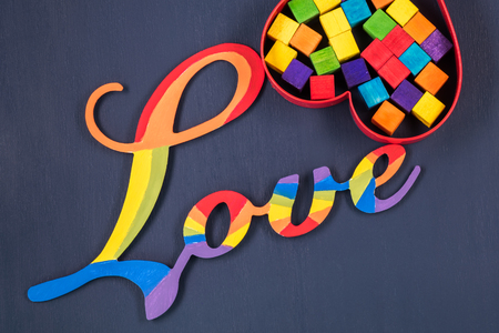 Gay pride. Rainbow colored word of love and wood pieces in metal shaped heart.の写真素材