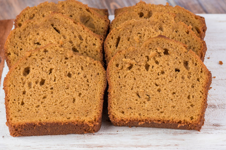 Cut  pumpkin cream cake on a cutting board.