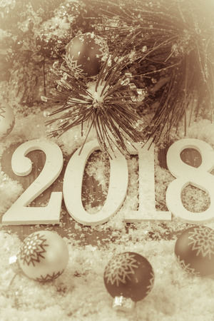 Background New 2018 Year with numbers, fir, balls in snow.