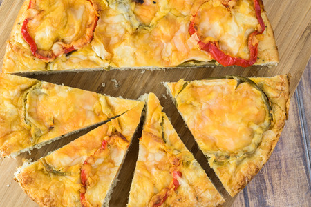 Close up of cut bell pepper cheese focaccia on a cutting board.