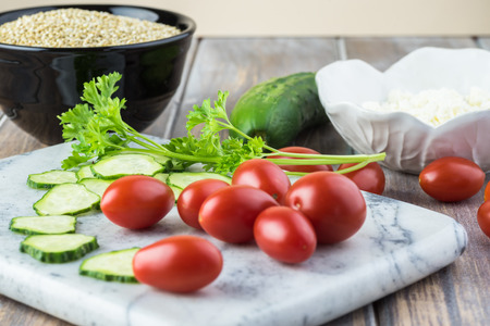 Close up of ingredients for quinoa mediterranean salad. Tomatoes, cucumble, quinoa grains.の写真素材