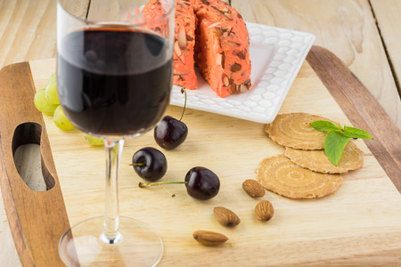 Close up of  board with spreadable port wine cheese and glass of red wine.の写真素材