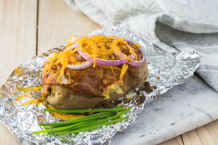 Close up of  loaded baked potatoes with  chili, onion, cheese.の写真素材