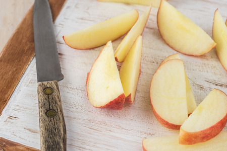 Close up of cutting board with cut apples - ingredient for roasted brussels sprouts.の写真素材