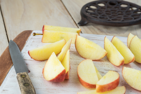 Close up of cutting board with cut apples - ingredient for roasted brussels sprouts.の写真素材