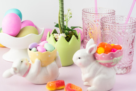 Close up of table decorated with bunny figurines, flower, eggs,  for Easter celebration.