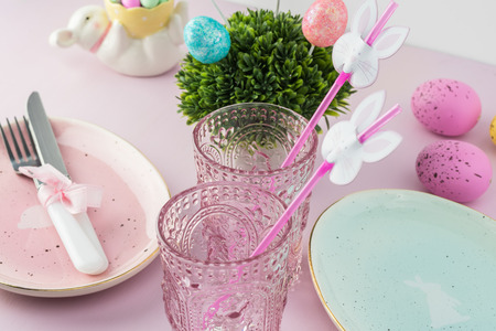 Close up of table decorated with flower, eggs, egg shaped plates for Easter celebration.