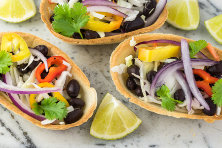 Close up of mini taco boats with black beans and vegetables.