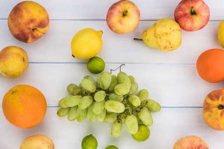 Top view of fresh fruits - peaches, apples, pears, grapes of new harvest on a wooden background.の写真素材