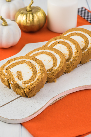 Close up of cut pumpkin cake roll on a white plate.の写真素材
