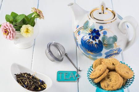 Close up of dry green tea, tea infuser, teapot on a wooden background.の写真素材