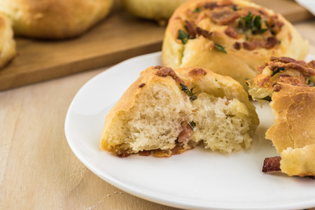 Fresh baked cheesy bacon holiday rolls on a plate.の写真素材