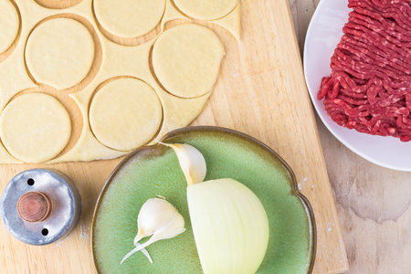 Close up of ingredients for beef dumplings - cut crust, ground beef, garlic, onion.の写真素材