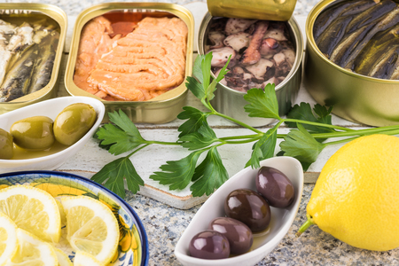 Close up of varieties of open  canned fish. Tin cans with smoked salmon fillets, sardines, calamari, sprats.の写真素材