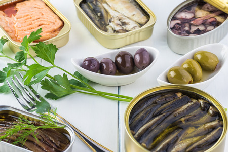 Close up of varieties of open  canned fish. Tin cans with smoked salmon fillets, sardines, calamari, sprats.の写真素材