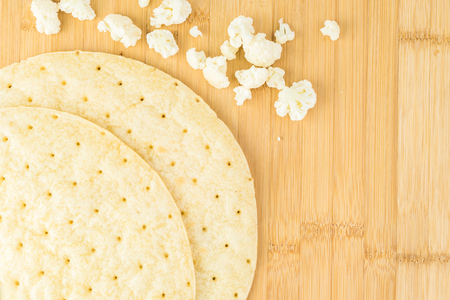 Close up of cauliflower pizza crust on a cutting board. Copy space.の写真素材