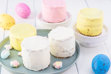 Close up of frosted mini vanilla cakes prepared for Easter celebration.