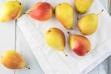 Close up of colorful ripe pears on wooden background.の写真素材