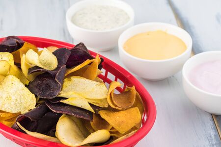 Basket of delicious, healthy mixed exotic roots chips and healthy dips - dill greek yogurt,...