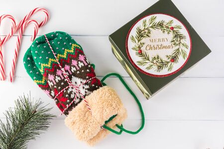 Close up of mittens with Christmas pattern and gift box.