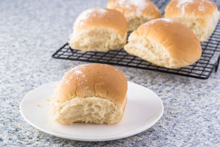 Close up of white plate with fresh baked potato roll.