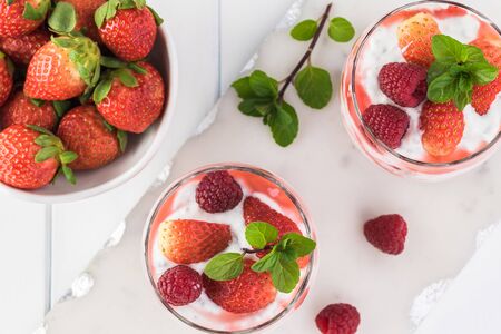 Top view of glasses with chia pudding with stawberry sauce and berries.