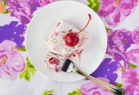Piece of frozen fruit salad decorated with  cherry.