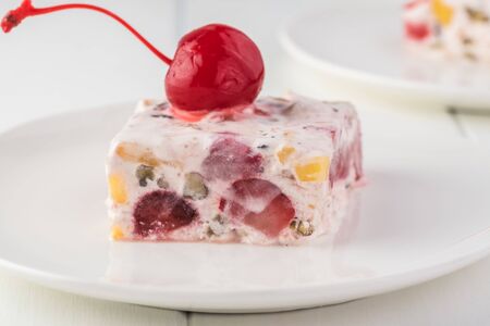 Piece of frozen fruit salad decorated with  cherry.の写真素材