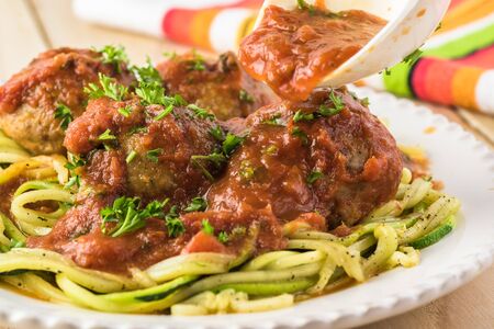 Plate with zucchini spaghetti and meatballs in marinara sauce.の写真素材