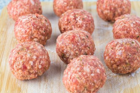 Raw meatballs on a cutting board.の写真素材