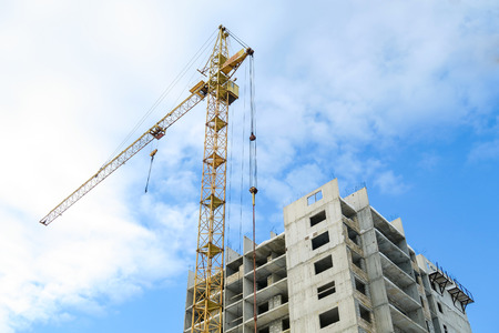 Photo: unfinished building and crane tower during sunriseの写真素材