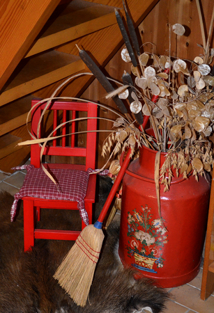 Still-life in red with milkcan, small chair and broomの写真素材