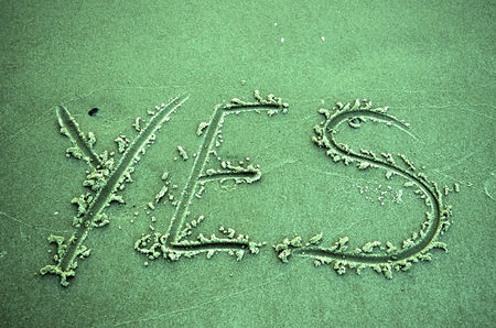The word YES written in sandの写真素材