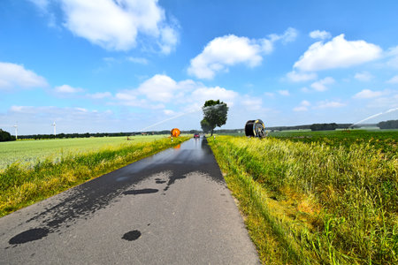 Lueneburg Heath, Germany - June 4, 2018: Road through fields that are watered by sprinklers in the Lueneburger Heath, Germanyのeditorial素材