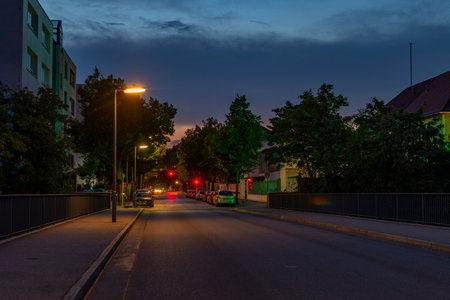 Berlin, Germany - July 27, 2018: Night shot of a side street with lit lanterns, traffic lights and star-shaped halosのeditorial素材