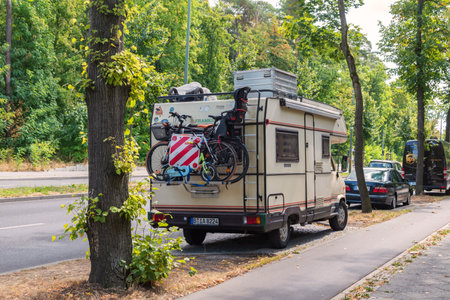 Berlin, Germany - August 26, 2018: A camping van with a cycle carrier attached to the rear with two bicycles with infant seat and a child's bike.のeditorial素材