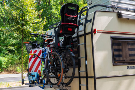 Berlin, Germany - August 26, 2018: A camping van with a cycle carrier attached to the rear with two bicycles with infant seat and a child's bike.のeditorial素材