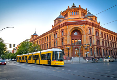 Berlin, Germany - June 30, 2018: View of a large intersection with a historic post office in Berlin Mitte, Germany, with a tram in the foreground in the evening sun.のeditorial素材