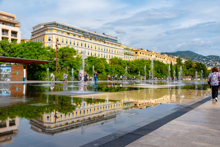 Nice, France - October 6, 2018: Beautiful historic buildings downtown Nice, France, reflected in the water that covers the floor of a place.のeditorial素材