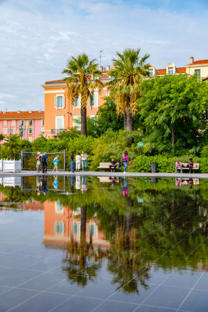 Nice, France - October 6, 2018: Beautiful historic buildings downtown Nice, France, reflected in the water that covers the floor of a place.のeditorial素材