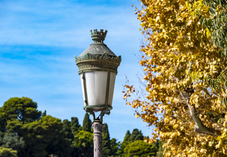 Scene in Nice, France, with an old lantern near a tree in front of blue sky.の写真素材