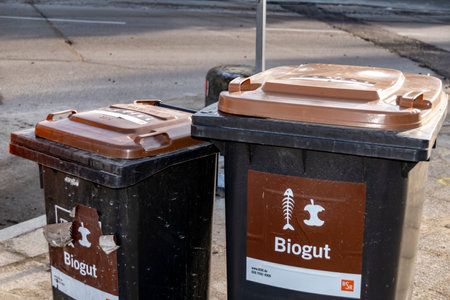 Berlin, Germany - January 19, 2019: Garbage bins at the roadside with sticker on for organic waste from the household, indicating what may be thrown into the bin.のeditorial素材