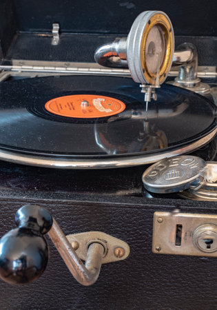Berlin, Germany - April 1, 2019: Components of an old gramophone from the company Odeon from Germany in the 1920s with a shellac disc, pickup, a box for the plate needles and the crank for the drive.のeditorial素材